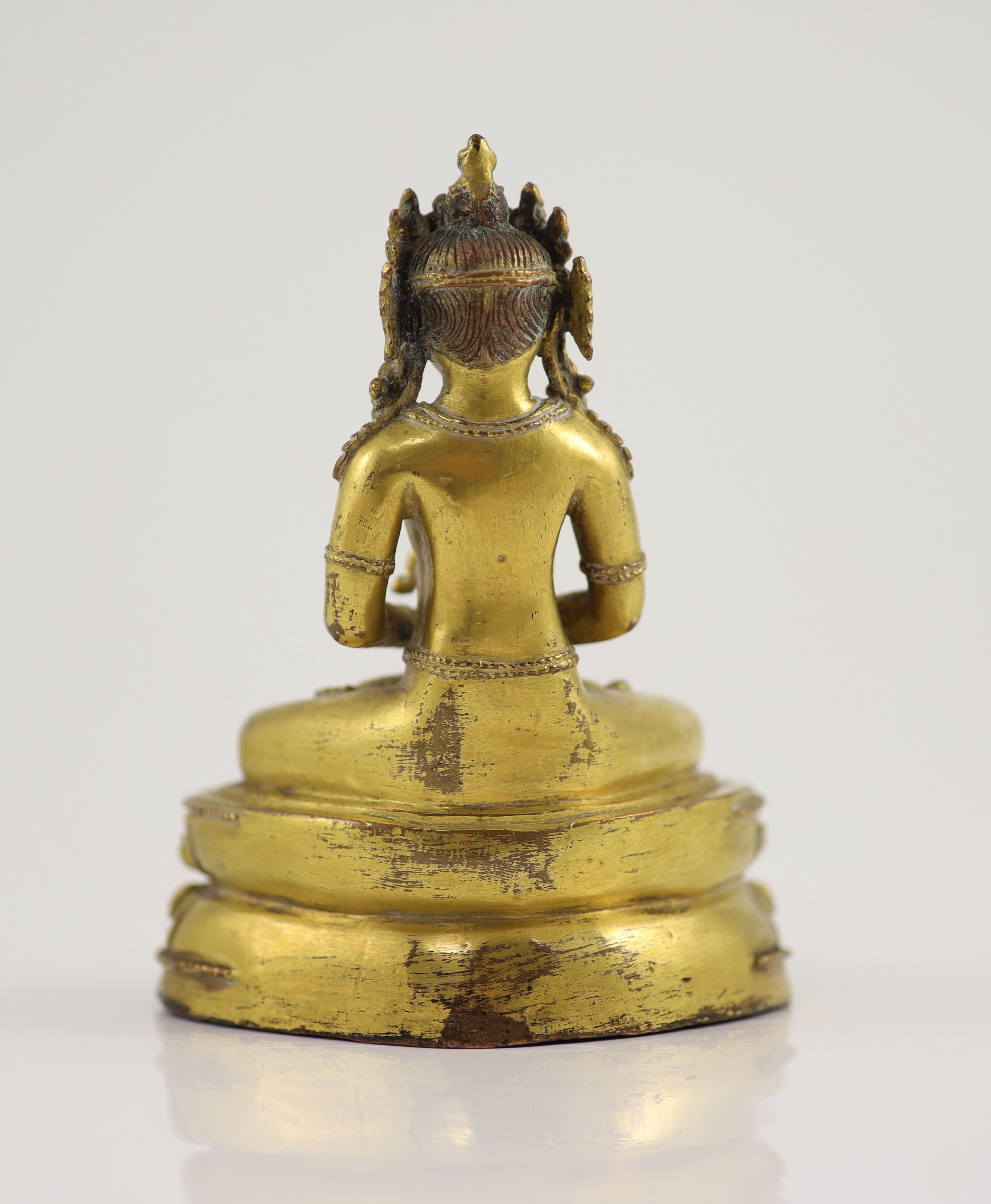 A Tibetan gilt copper alloy seated figure of Amitayus, probably 15th/16th century, 15cm high